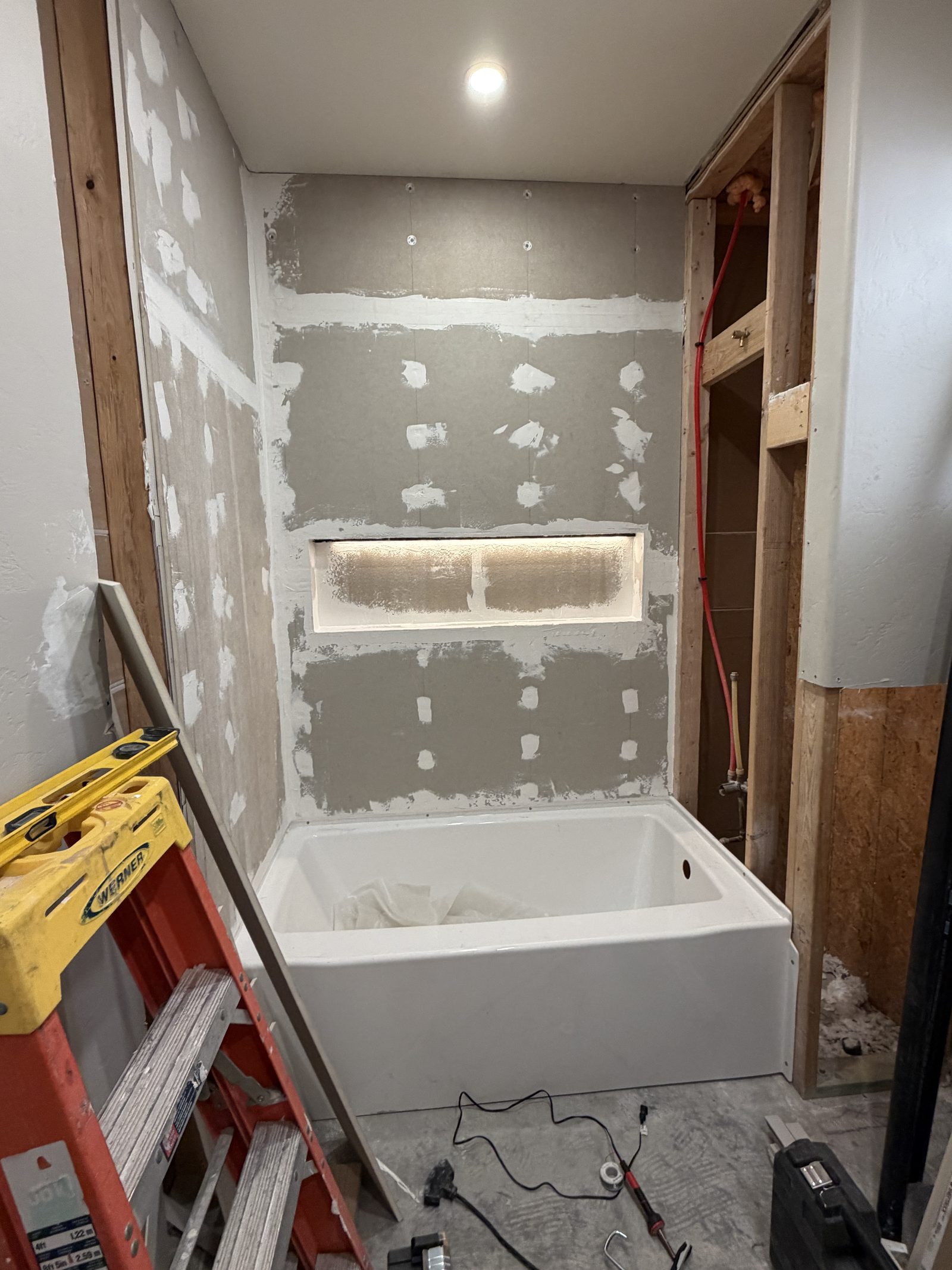 Bathroom mid-remodel, drywall taped and tub set